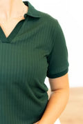 Green polo shirt worn by a person on a white background